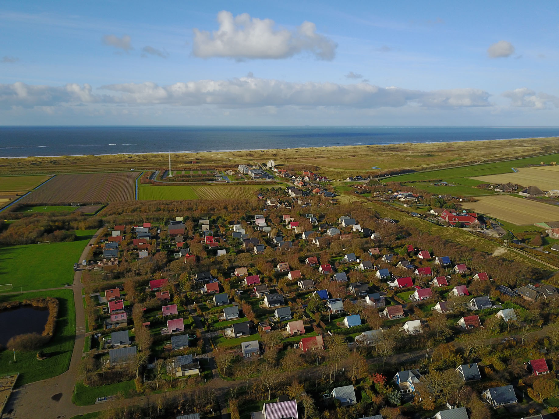 DCIM100MEDIADJI_0003.JPG Luchtfoto Sandepark. Groep met huisjes en op loopafstand de duinen, het strand en de zee.