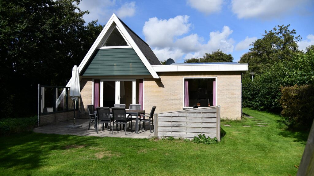 Sandepark 69. Stenen uitgebouwd huis, met ruim terras me tuintafel en tuinstoelen.