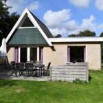 Sandepark 69. Stenen uitgebouwd huis, met ruim terras me tuintafel en tuinstoelen.