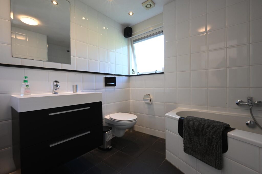 Sandepark 69. Badkamer met douche, ligbad, toilet en badmeubel.