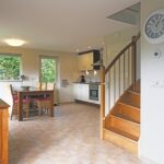 Sandepark 88. Overzichtsfoto woonkamer met vaste trap naar de verdieping, 6 persoons eettafel en keuken.