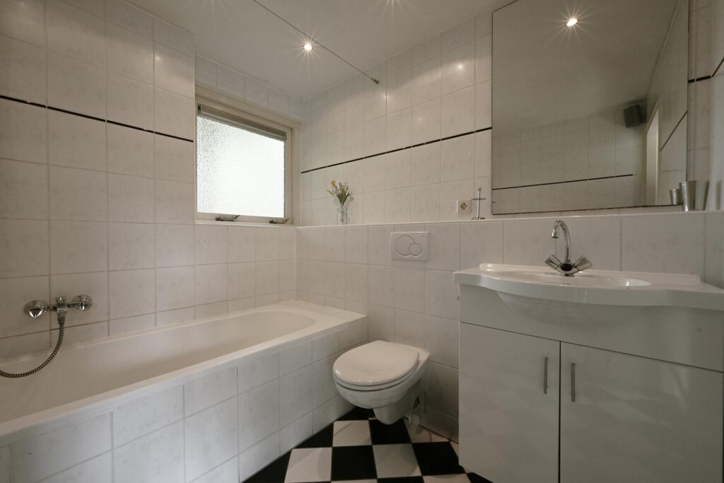Sandepark 88. Badkamer met douche, ligbad, toilet en badmeubel.
