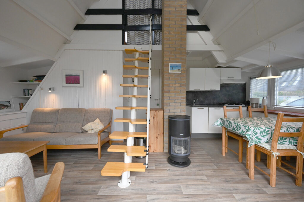 Sandepark 70. Overzichtsfoto woonkamer kamer met een zithoek, 6 persoons Eettafel en eenvoudige keuken.