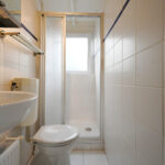Sandepark 70. Compacte badkamer met wasbak, toilet en douche.